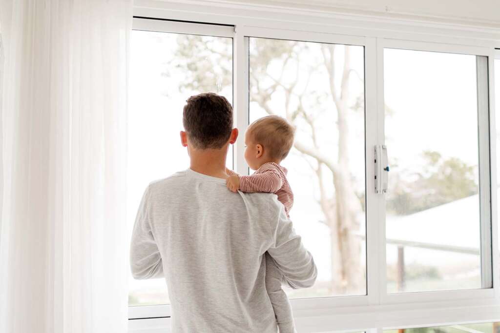 Dad and baby looking out the window