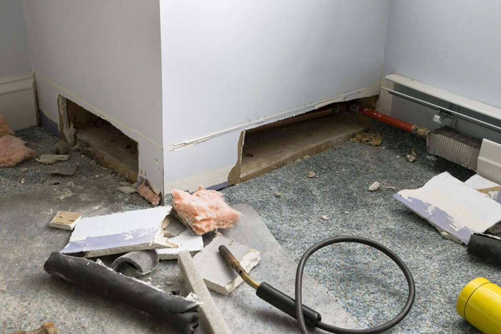 Baseboards cut open to find leaky or broken pipes