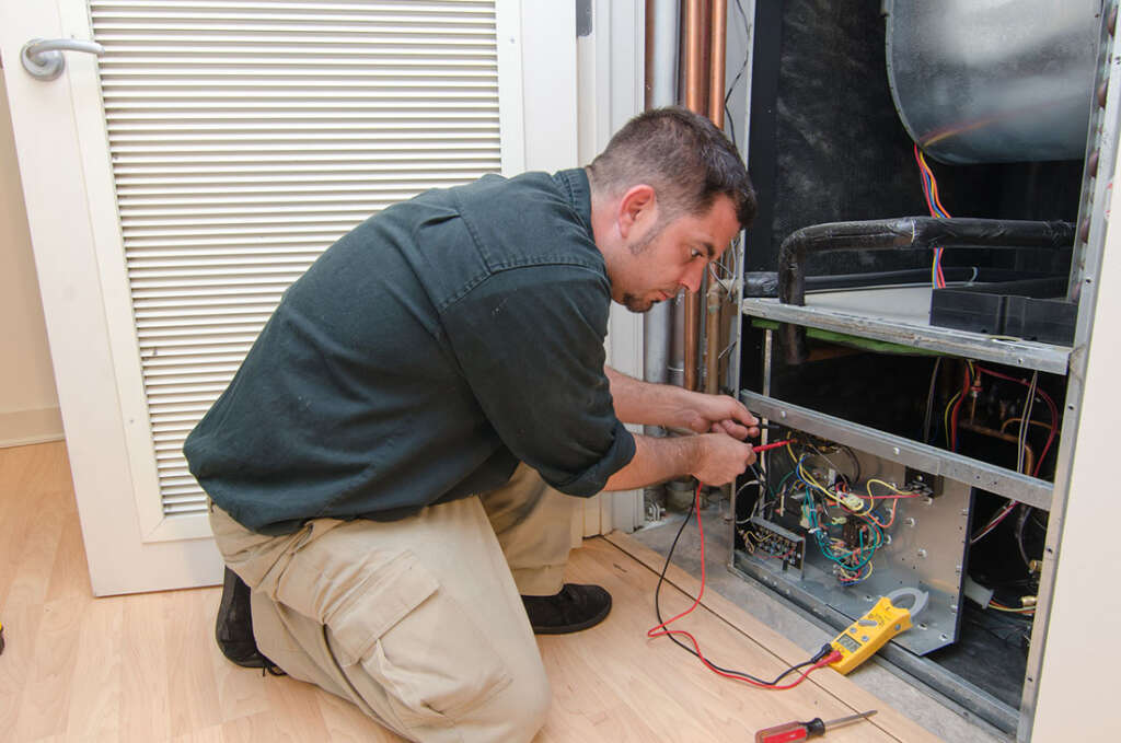 Technician examines furnace for efficiency