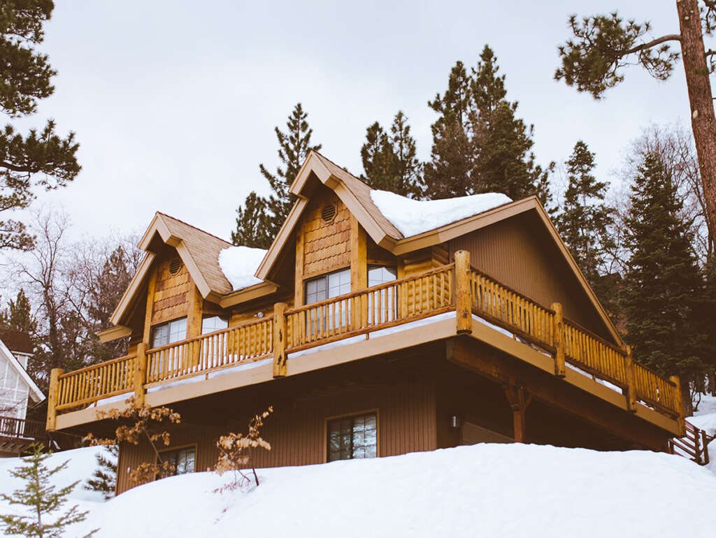 Log cabin in the mountains covered in snow