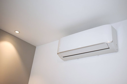 A mini split system is pictured on a white wall.